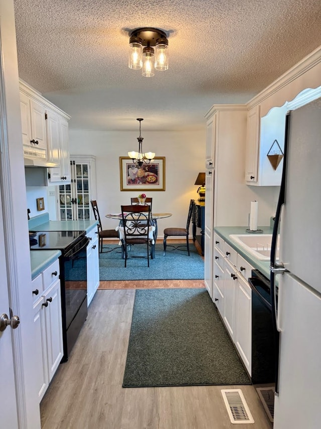 4511 Crestway Dr, Cohutta, GA 30710 - kitchen featuring black appliances, light wood finished floors, under cabinet range hood, a chandelier, and light countertops