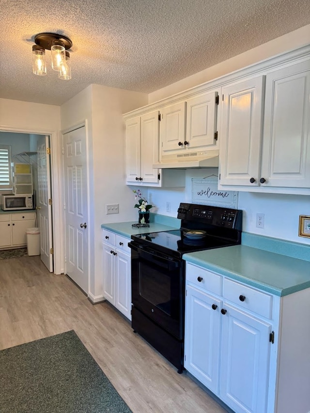 4511 Crestway Dr, Cohutta, GA 30710 - kitchen with black range with electric stovetop, under cabinet range hood, white microwave, light wood-type flooring, and a textured ceiling