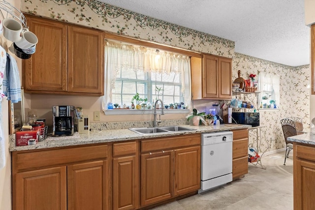 kitchen featuring white dishwasher, wallpapered walls, and a sink