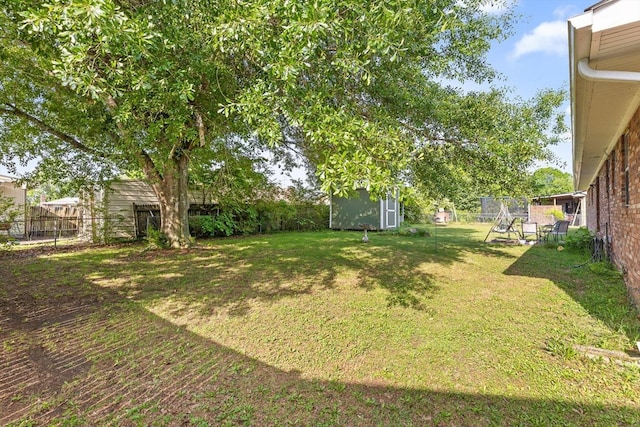 view of yard featuring a fenced backyard, a shed, and an outbuilding