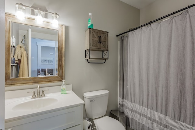 bathroom with curtained shower, vanity, and toilet