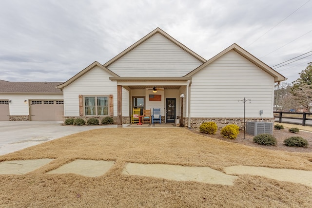 view of front of home with central air condition unit, fence, brick siding, an attached garage, and concrete driveway