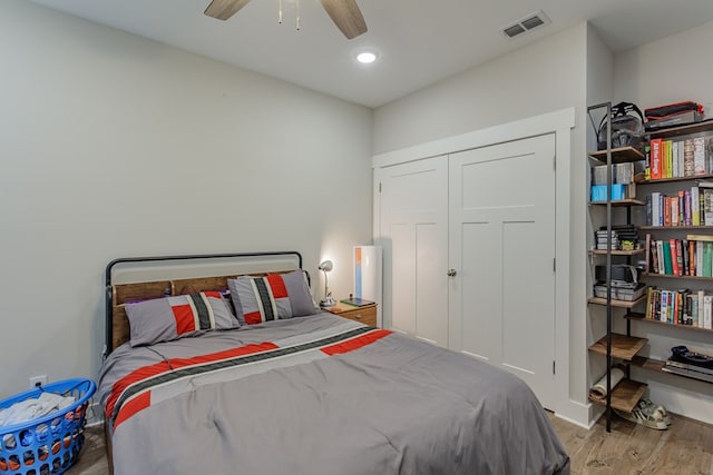 bedroom with ceiling fan, a closet, visible vents, wood finished floors, and baseboards