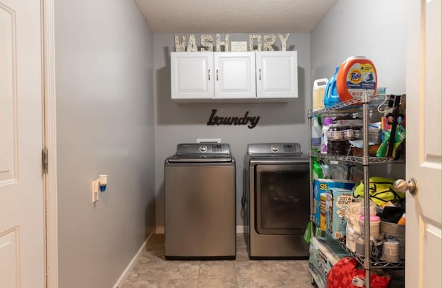 laundry area featuring cabinets, separate washer and dryer, and a textured ceiling