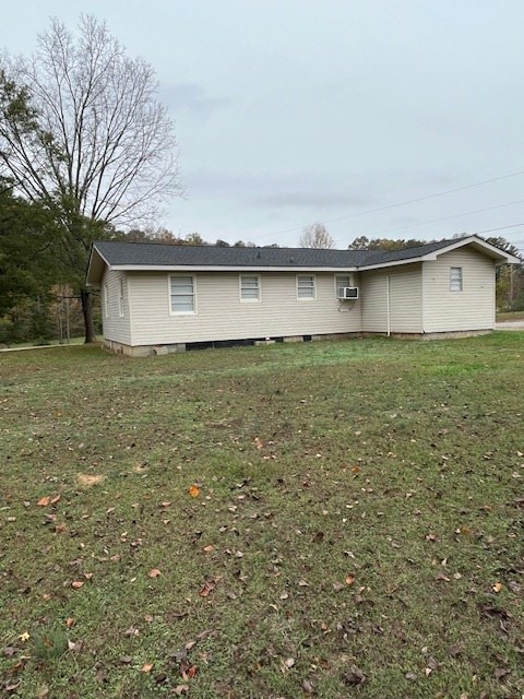 rear view of house featuring a yard and a wall mounted air conditioner