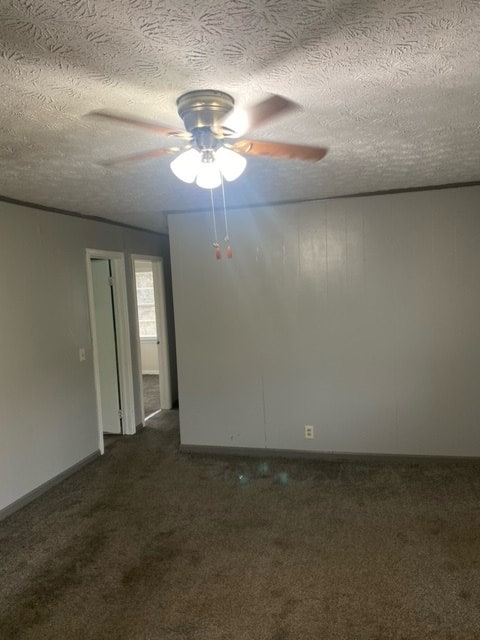 carpeted empty room with ceiling fan and a textured ceiling