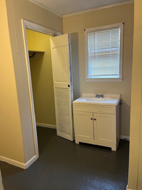 bathroom featuring concrete flooring, sink, and ornamental molding