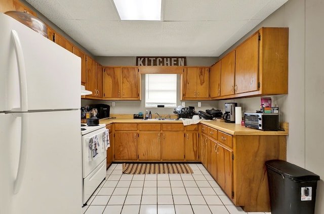 kitchen featuring sink, white appliances, and light tile patterned flooring