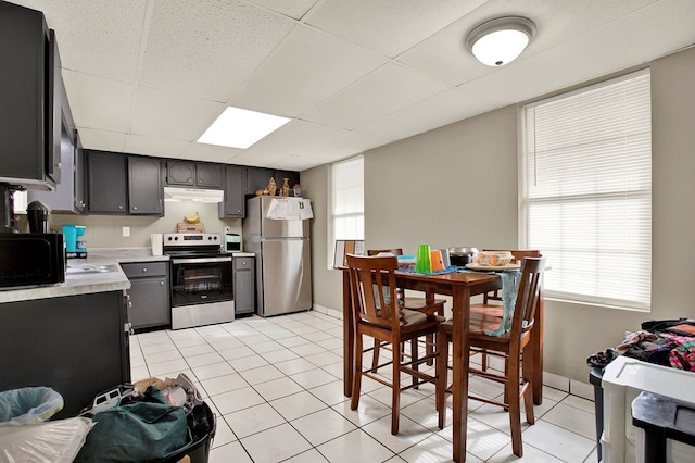 kitchen featuring appliances with stainless steel finishes, gray cabinets, a drop ceiling, and light tile patterned floors