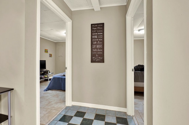 corridor with a paneled ceiling