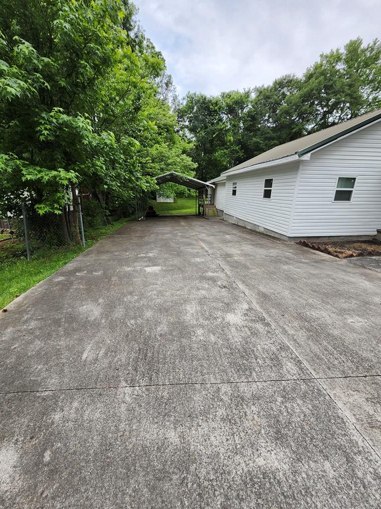 1712 Wendell St, Dalton, GA 30721 - view of patio / terrace with a detached carport, concrete driveway, and view of scattered trees