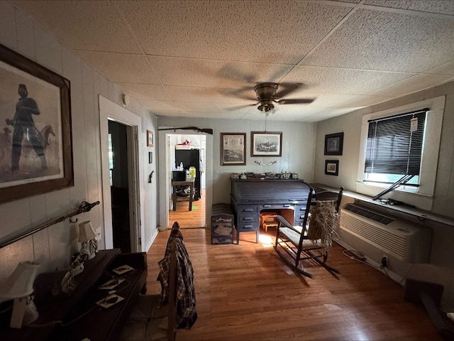 bedroom featuring wood-type flooring, a wall mounted air conditioner, and wooden walls