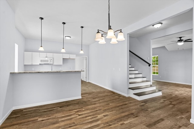 429 Glenwood Ave, Dalton, GA 30721 - kitchen with white microwave, white cabinets, dark wood-style floors, a chandelier, and light stone countertops