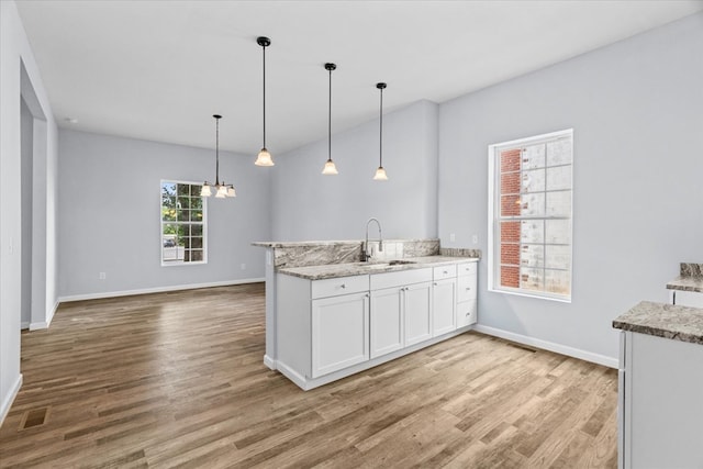 429 Glenwood Ave, Dalton, GA 30721 - kitchen featuring wood finished floors, white cabinetry, a peninsula, decorative light fixtures, and a chandelier