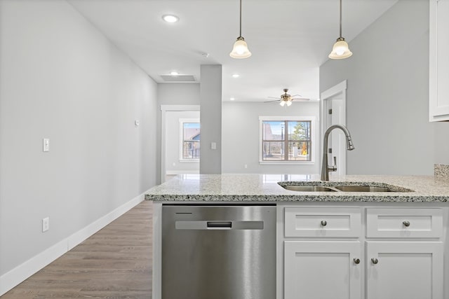 kitchen with white cabinets, dishwasher, decorative light fixtures, light stone countertops, and a sink