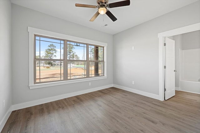 empty room featuring a ceiling fan, baseboards, and wood finished floors