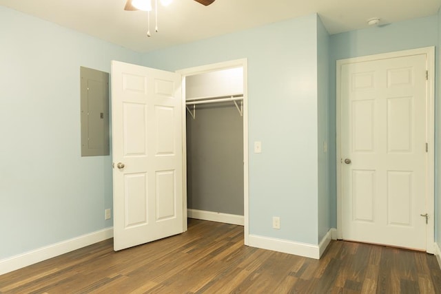 unfurnished bedroom featuring dark wood-type flooring, ceiling fan, electric panel, and a closet