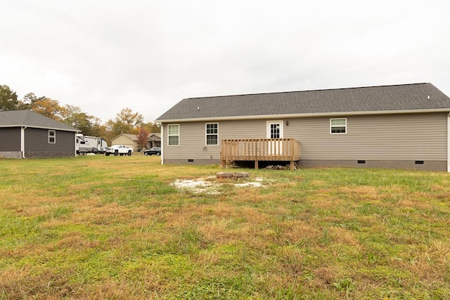 back of property with a wooden deck and a lawn