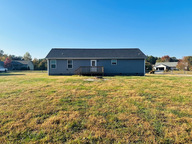 back of property featuring a wooden deck and a lawn