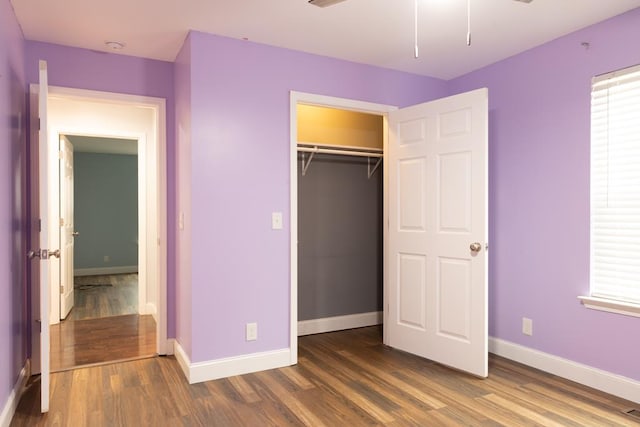 unfurnished bedroom with a closet and dark hardwood / wood-style floors