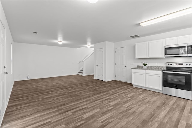 132 Village Creek Dr, Chatsworth, GA 30705 - kitchen with stainless steel appliances, open floor plan, wood finished floors, white cabinets, and baseboards