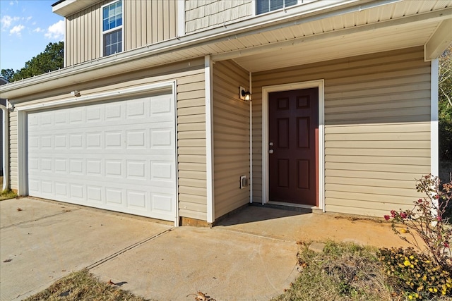 132 Village Creek Dr, Chatsworth, GA 30705 - view of exterior entry with an attached garage and board and batten siding