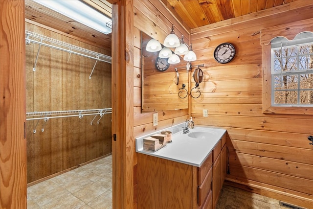 bathroom with vanity, wooden walls, and wooden ceiling