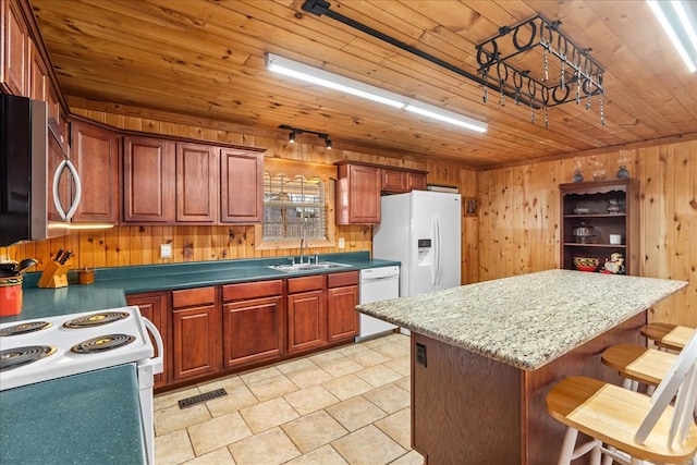 kitchen with sink, white appliances, a kitchen breakfast bar, a kitchen island, and wooden ceiling