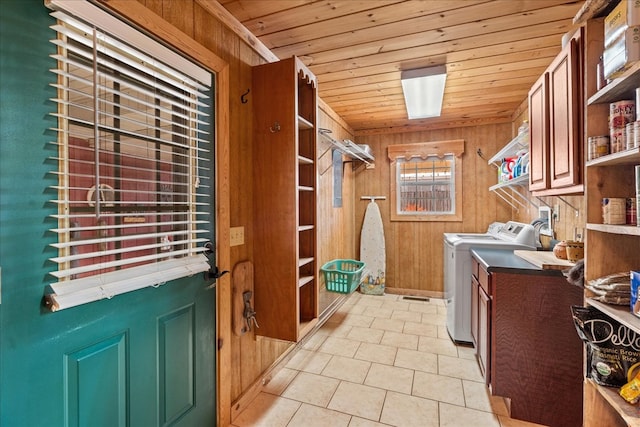 laundry room with cabinets, washing machine and clothes dryer, wooden walls, and wooden ceiling