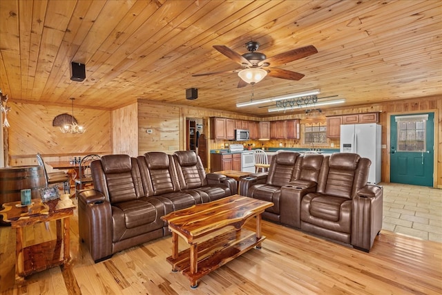 living room featuring ceiling fan with notable chandelier, wooden ceiling, light wood-type flooring, and wood walls