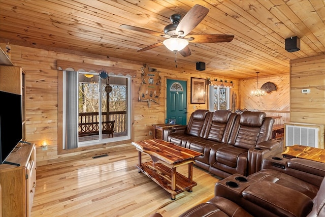 living room featuring wood ceiling, wooden walls, light hardwood / wood-style floors, and plenty of natural light