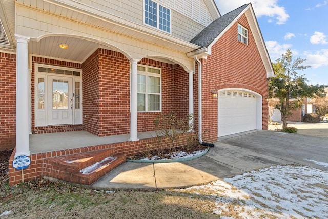 doorway to property with a garage and covered porch