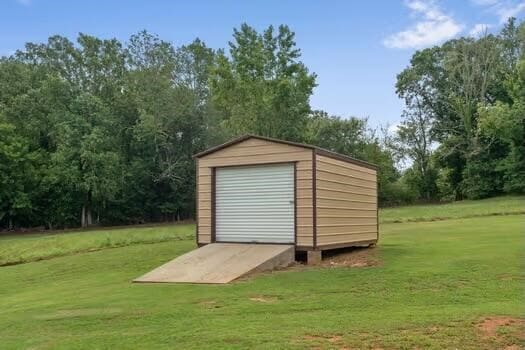 view of outdoor structure featuring a yard and a garage