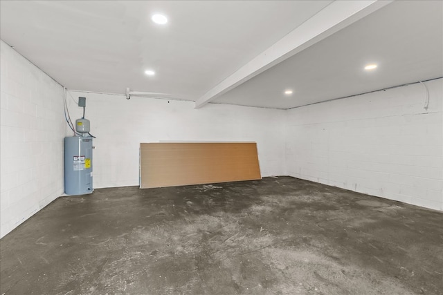 finished below grade area featuring electric water heater, concrete block wall, and recessed lighting