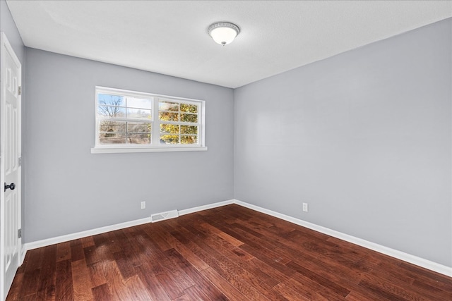 empty room with hardwood / wood-style flooring and a textured ceiling