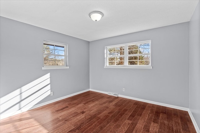 unfurnished room with hardwood / wood-style flooring and a textured ceiling