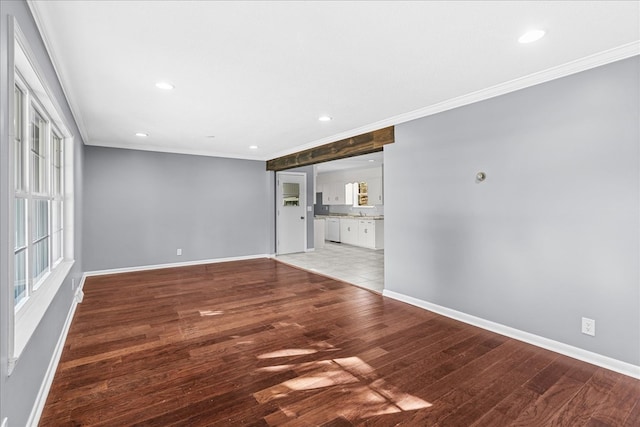 unfurnished living room with crown molding, plenty of natural light, and wood-type flooring