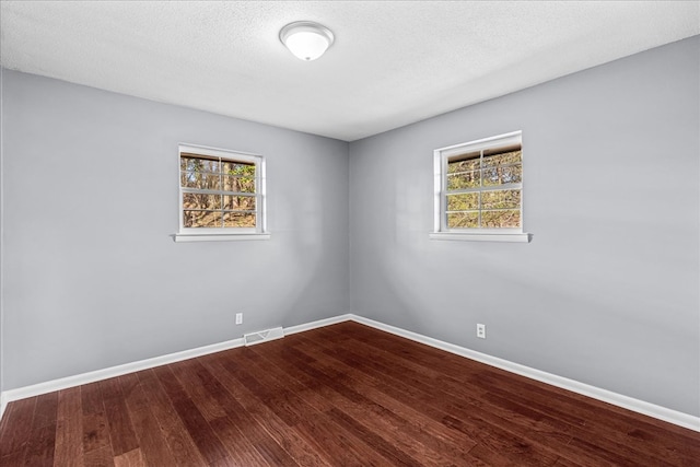 unfurnished room featuring hardwood / wood-style floors and a textured ceiling