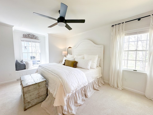 carpeted bedroom with ornamental molding, baseboards, multiple windows, and ceiling fan