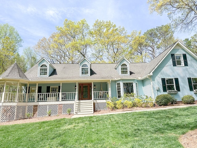 new england style home with a shingled roof, a porch, and a front lawn