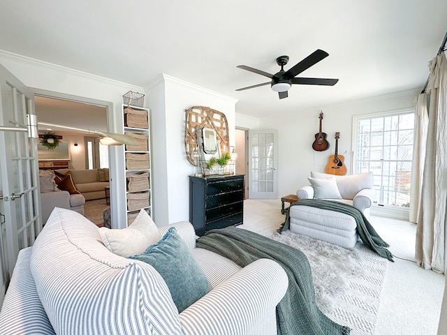 carpeted living room featuring french doors, a ceiling fan, and ornamental molding