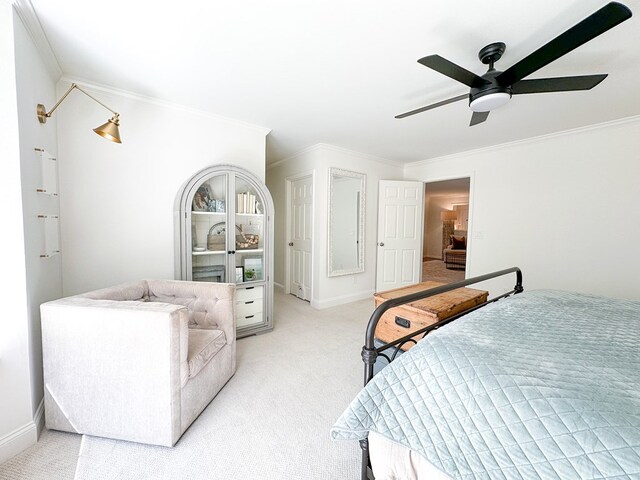bedroom featuring light carpet, ceiling fan, crown molding, and baseboards