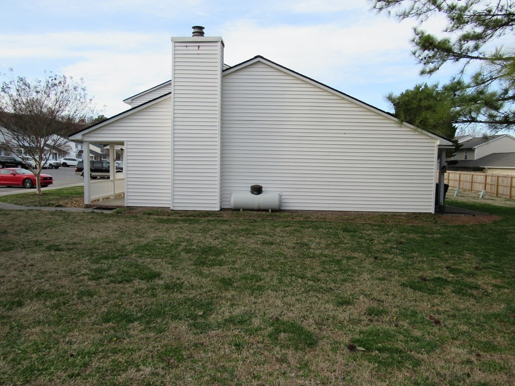 view of property exterior featuring a chimney and a yard