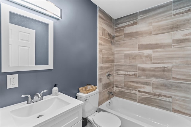 full bathroom featuring vanity, tiled shower / bath combo, and toilet