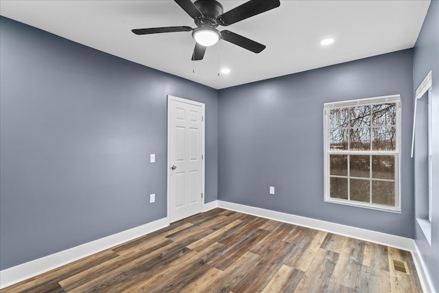 spare room featuring dark wood-type flooring and ceiling fan