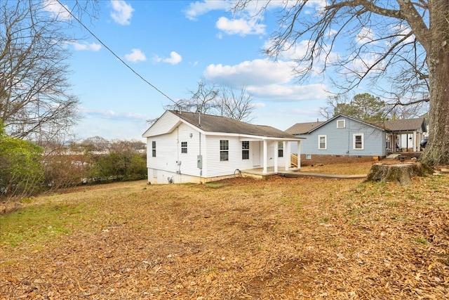 rear view of house featuring a yard