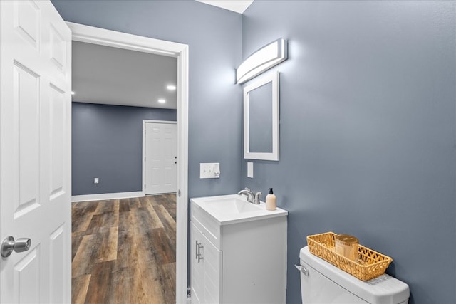 bathroom featuring wood-type flooring, toilet, and vanity