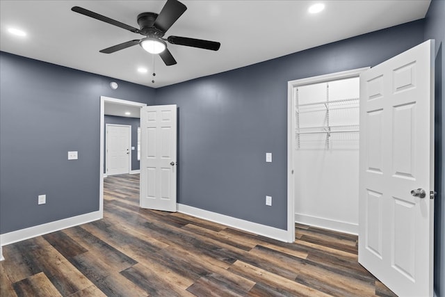 unfurnished bedroom with dark hardwood / wood-style flooring, a closet, and ceiling fan