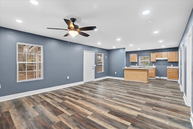 kitchen featuring ceiling fan, a kitchen island, and dark hardwood / wood-style flooring