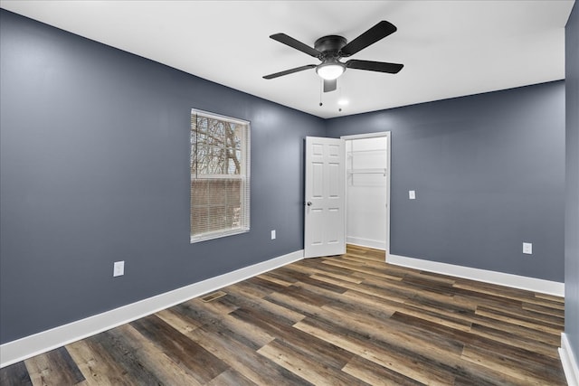 unfurnished room with ceiling fan and dark hardwood / wood-style flooring